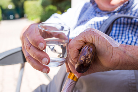 Elderly man with glass of water in handの写真素材