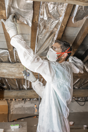 Man makes thermal insulation of the attic of the houseの写真素材