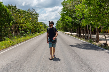 Man walking on a Mexican road surrounded by jungleの写真素材