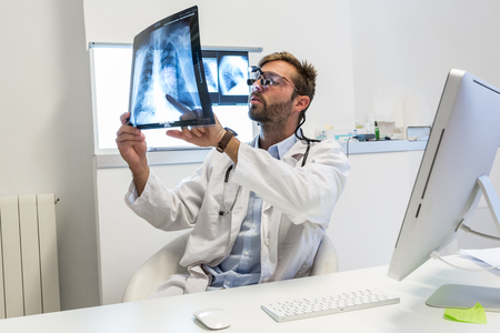 Serious attractive doctor examining an x-rayの写真素材