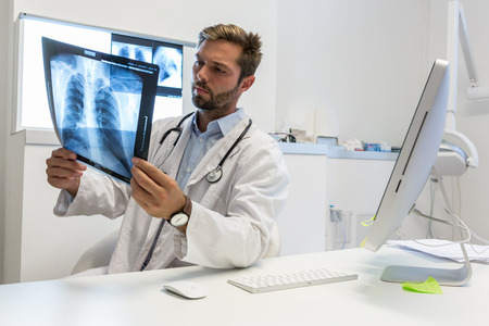 Serious attractive doctor examining an x-rayの写真素材
