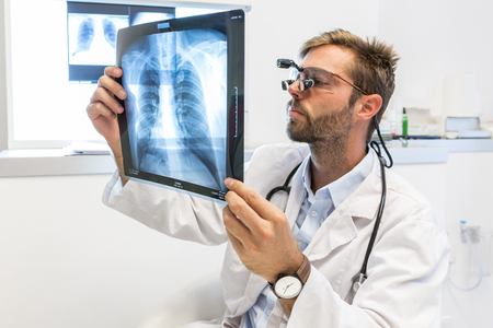 Serious attractive doctor examining an x-rayの写真素材