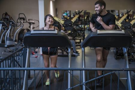 Attractive young people working out cardio on treadmill machineの写真素材