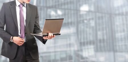 businessman standing works on laptopの写真素材