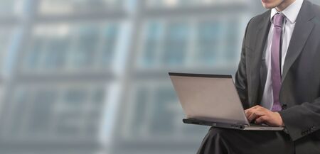 Businessman seated works on laptopの写真素材