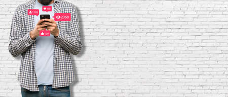 Social media concept - Banner with young man holding smartphone and with social media iconの写真素材