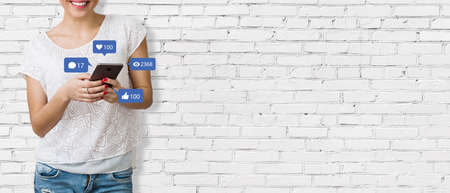 Social media concept - Banner with unrecognizable woman holding smartphone and with social media...