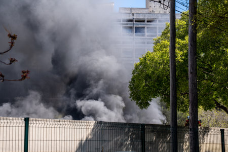 Dangerous black smoke from a huge fire in the cityの写真素材