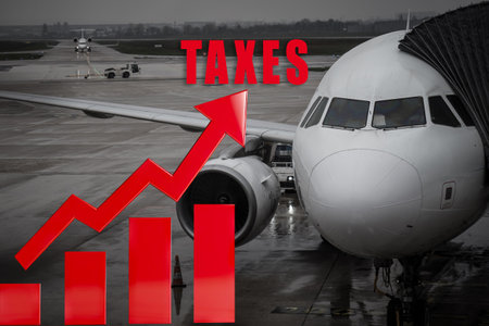 Red arrow with the word TAXES on the background of an airplaneの写真素材
