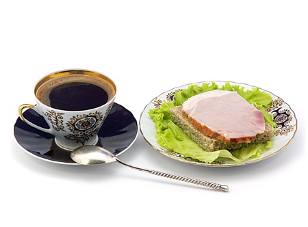 A cup of coffee and a plate with a sandwich. White backgroundの写真素材