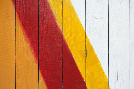 Red and yellow stripes on a wooden wall, closeup of photo. colorful wooden textureの写真素材