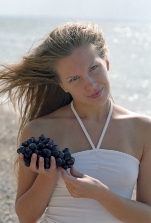 woman with grapes on a beach の写真素材