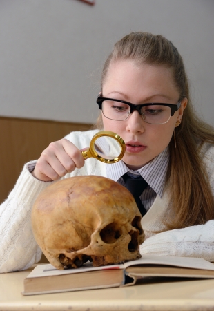 Woman examining a human skullの写真素材
