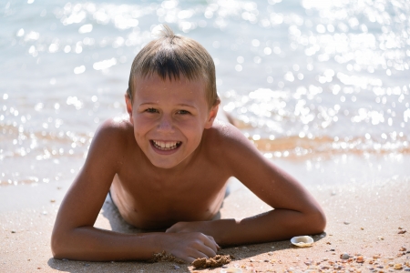 boy lying on the beachの写真素材