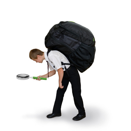 schoolboy carries a backpack and magnifying glassの写真素材