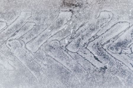 Automobile track on snow from tire on ice roadの写真素材