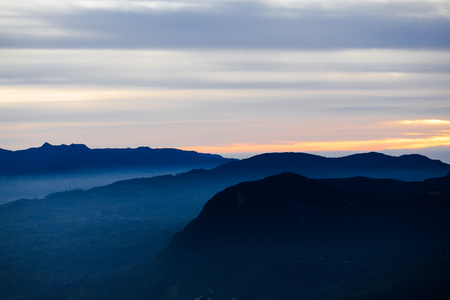 Blue landscape with mountains and morning fog. Cloudy sunriceの写真素材