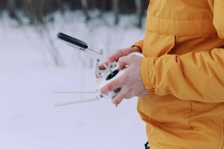 A hand holding a drone controller. Young male tourist Using drone photographs and shoots natureの写真素材