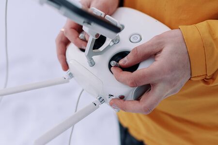 A hand holding a drone controller. Young male tourist Using drone photographs and shoots natureの写真素材