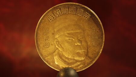 Ancient Chinese bronze coin with the image of a man in a hat and inscriptions of hieroglyphs.の写真素材