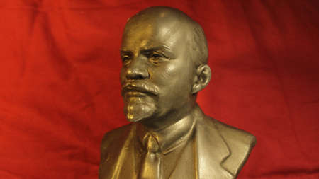 The copper bust of VI Lenin against a red background conveys the atmosphere of the period of...