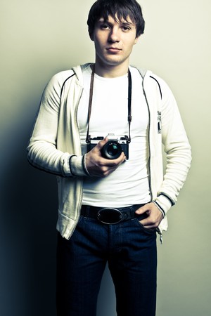 Photographer holding the film camera on light background. Contrast image.の写真素材
