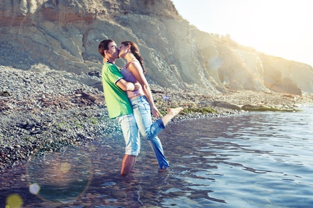 Lovers kissing passionately while standing ankle-deep in waterの写真素材