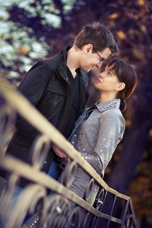 Young couple in the autumn park, looking in each others eyesの写真素材