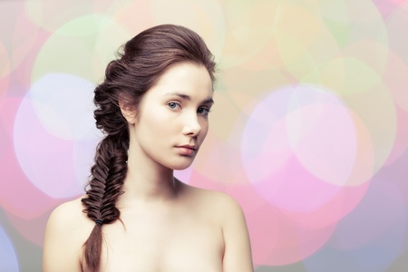 Young beautiful woman  with elegant hairdo on colorful pastel backgroundの写真素材
