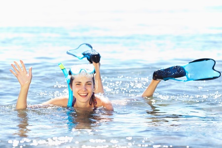 Beautiful tanned girl in snorkel gear waving her handの写真素材