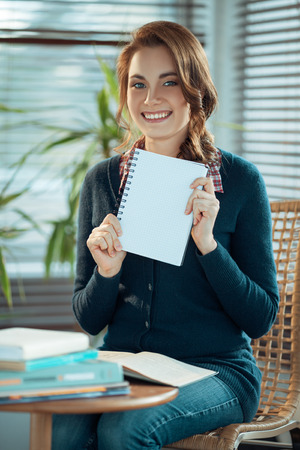 Pretty student showing a blank notebookの写真素材