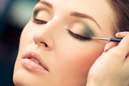 Make-up artist applying liquid eyeliner on model's eyes, close upの写真素材