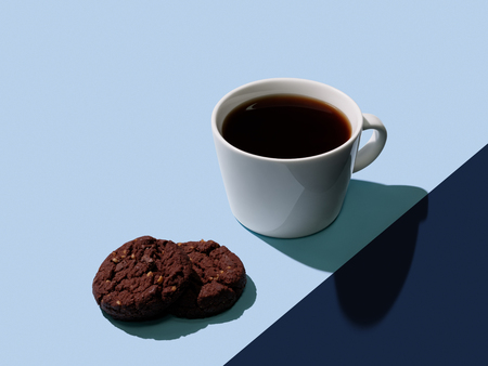 Cup of hot black coffee and fresh chocolate cookies on color block blue backgroundの写真素材