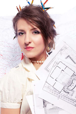 Eccentric designer holding working drawings, drawings on backgroundの写真素材