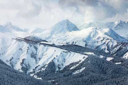 Snow covered mountain peaks in the clouds