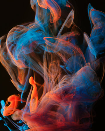 A mixture of colorful ink swirls in water on a black background. Abstract concept photo.の写真素材
