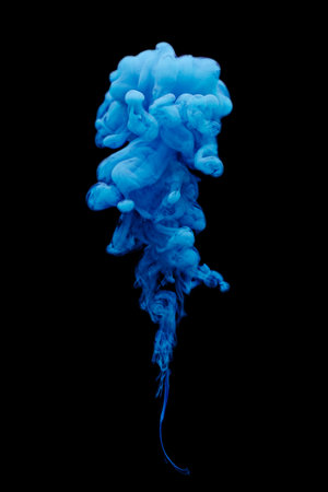 Blue ink swirling in water isolated on black background.の写真素材