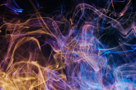 A mixture of colorful ink swirls in water on a black background. Abstract concept photo.の写真素材