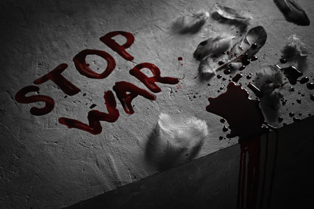 The description in blood "stop war", feathers and drops of blood. Anti-war concept.の写真素材