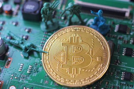 Bitcoin under attack four miniature men surrounded by pile of bitcoin. Miniature figurine toys standing near bitcoinの写真素材
