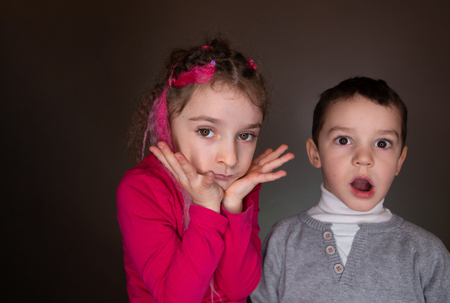 Boy and girl look to the camera in studioの写真素材