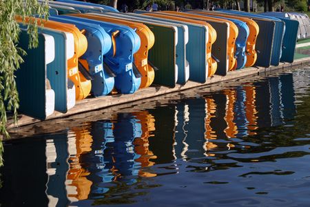 paddle boats reflections on green lakeの写真素材