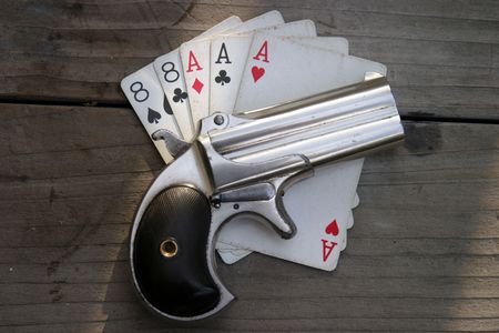 Circa 1889, Model 95, Type II Model 3 Double Derringer on antique wooden table with aces and eights (aka a Dead Mans Hand)の写真素材