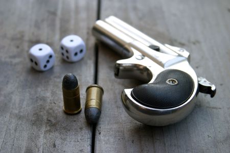 Circa 1889, Model 95, Type II Model 3 Double Derringer on antique wooden table with dice and ammoの写真素材