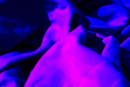 neon blue and pink cloth table napkins clumped up and wrinkled for backgroundの写真素材
