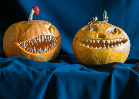 Halloween theme, carved pumpkin with a scary smile, burning candles, spiders and cobwebs, awful...