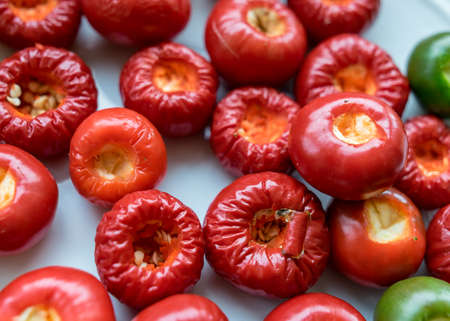picture with tomato peppers on a white plate, peppers prepared for canning, healthy eating concept, vegetarian diet, canning products for winter, autumn harvest timeの写真素材