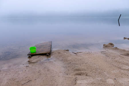 landscape with sandy beach after heavy rain, white fog on the lake, fuzzy contoursの写真素材