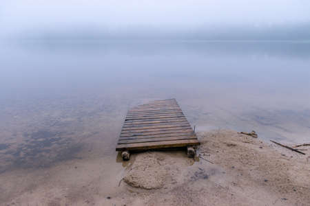 landscape with sandy beach after heavy rain, white fog on the lake, fuzzy contoursの写真素材