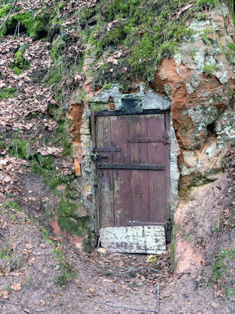 old wooden door fragments in sandstone wall cover cellars dug in sandstone rockの写真素材